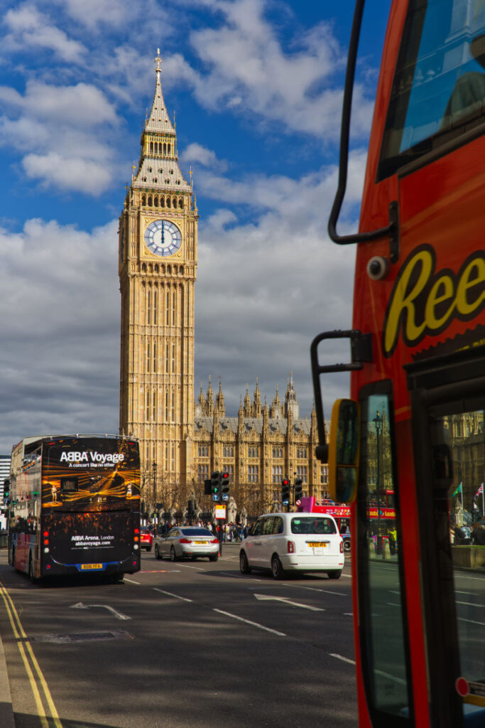 Roter Doppeldeckerbus als Vordergrund mit Big Ben und dem Palace of Westminster im Hintergrund, London