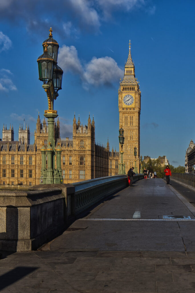 Blick entlang der Westminster Bridge auf Big Ben am frühen Morgen, grüne Laternenmasten im Vordergrund, London