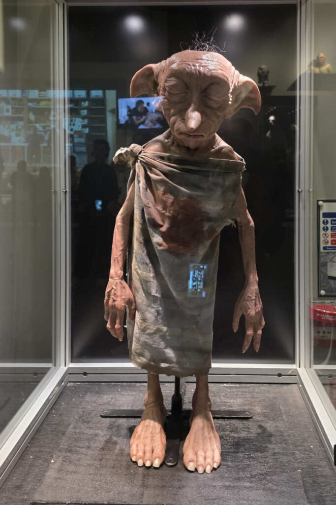 Lebensgroße Dobby-Figur in der Vitrine im Masken- und Make-up-Bereich der Harry Potter Studio Tour London.