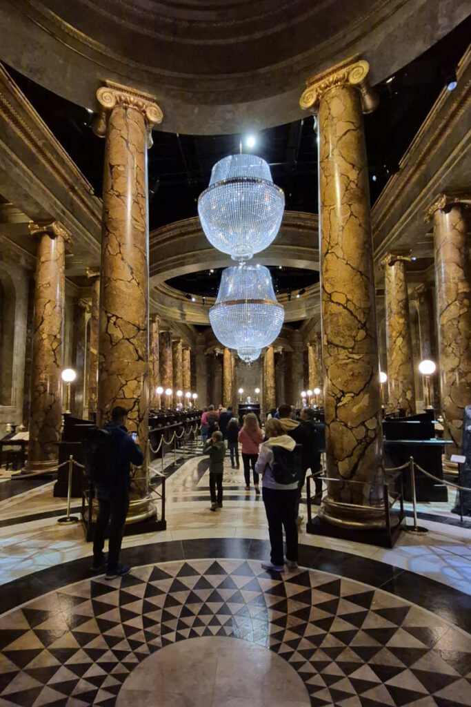 Der Gringotts-Banksaal mit mächtigen Marmorsäulen und Kristallkronleuchtern in der Harry Potter Studio Tour London.