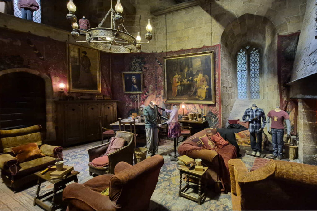 Der Gryffindor-Gemeinschaftsraum mit abgenutzten Sesseln, Wandteppichen und Öllampen in der Harry Potter Studio Tour London.