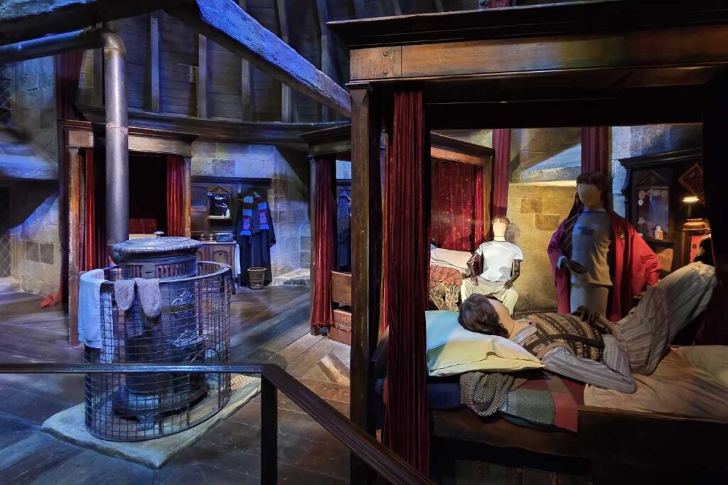 Gryffindor-Schlafsaal mit roten Himmelbetten in der Harry Potter Studio Tour London.