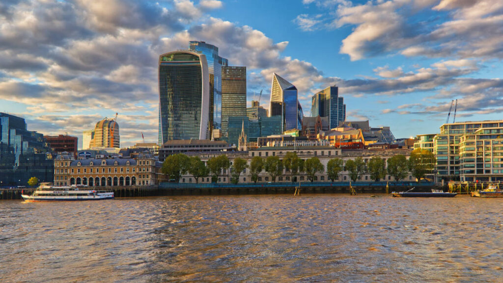 Skyline der City of London mit Boot auf der Themse im Abendlicht
