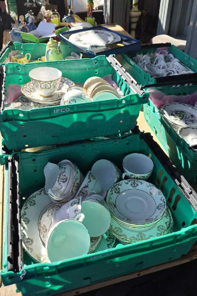 Antiquitätenstand am Portobello Road Market mit Porzellantassen und Teeservice in Kisten