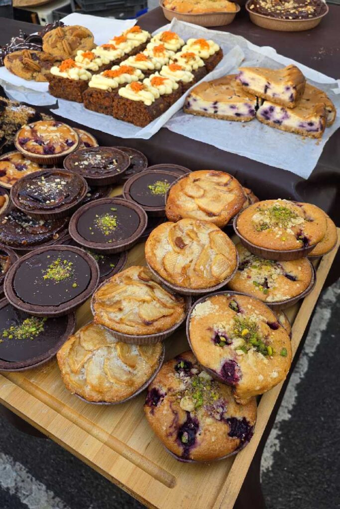 Backwarenstand am Portobello Road Market mit Muffins, Schokoladentörtchen und Karottenkuchen