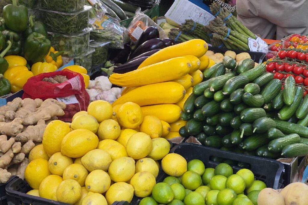 Bunter Obst- und Gemüsestand am Portobello Road Market mit Zitronen, Gurken, Paprika und Zucchini