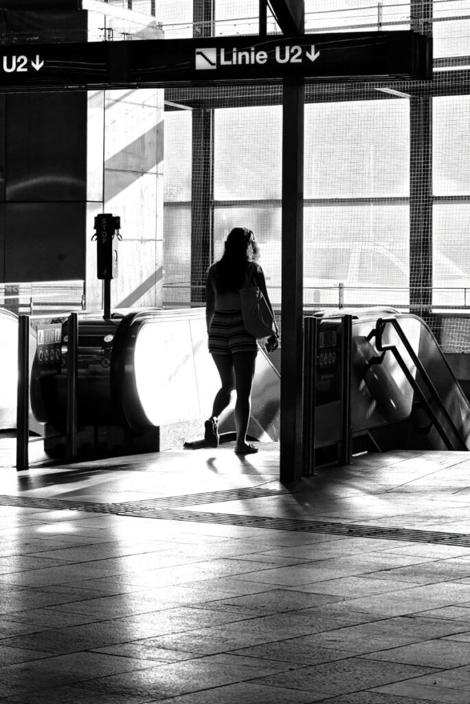 Silhouette einer Frau im Gegenlicht vor einer Rolltreppe an der Station Linie U2