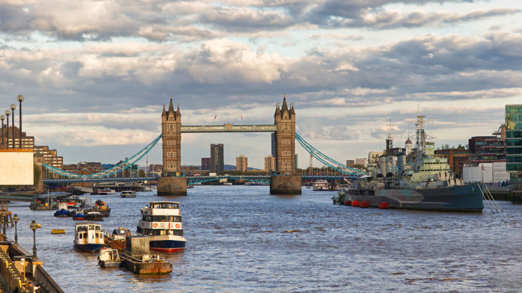 Tower Bridge von der London Bridge aus gesehen mit Wolkenhimmel und Booten auf der Themse