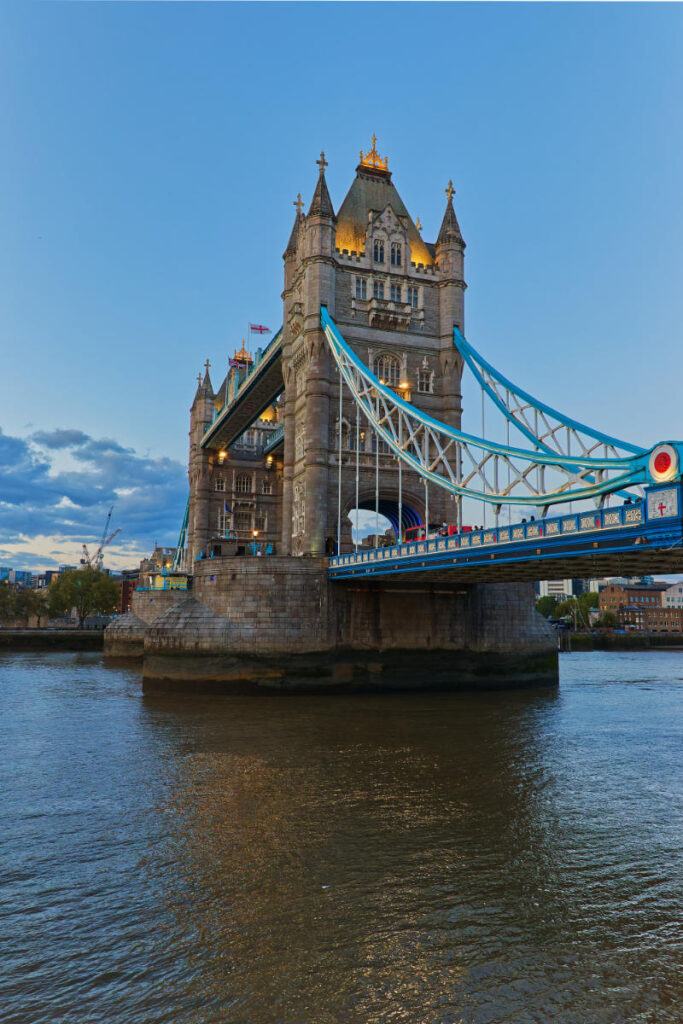Turm der Tower Bridge mit beleuchteten Fenstern und rotem Bus