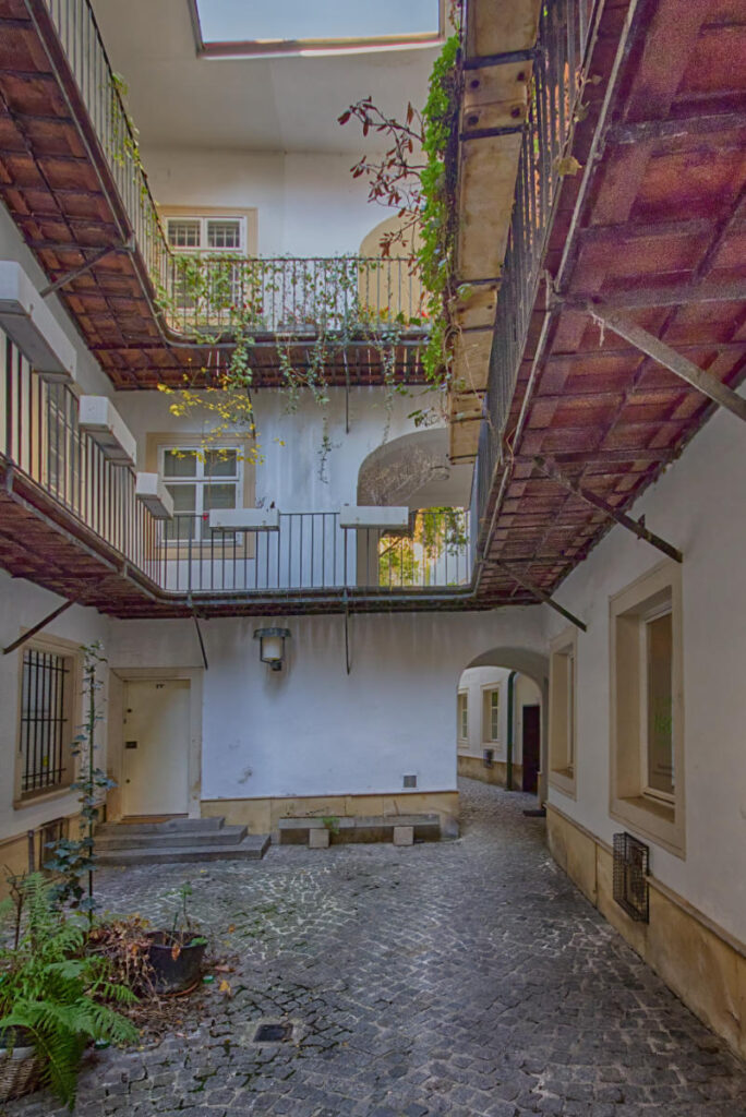 Pawlatschen im Fähnrichshof in Wien, offene Umlaufgänge mit Pflanzen an einem historischen Innenhof